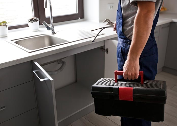 kitchen-plumbing-repair photo of a plumber fixing kitchen pipes